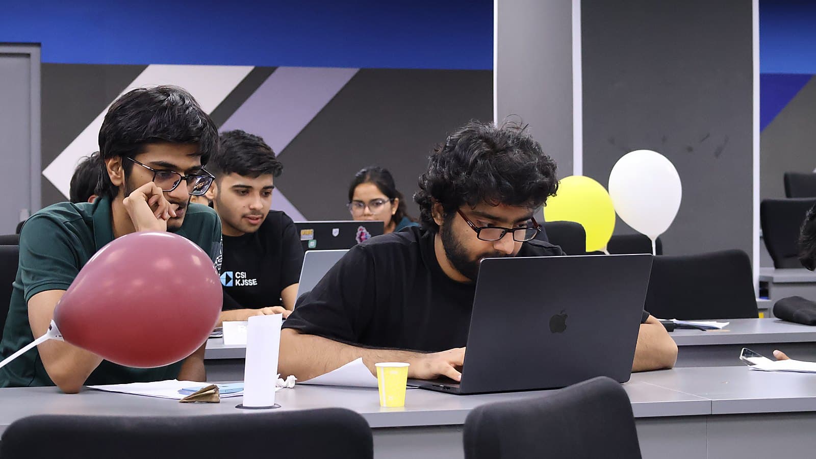 Teams mid-contest at RETRACK, balloons on the desks